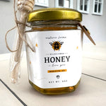 Jar of honey with a gold lid on a kitchen counter