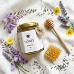 Honey jar with a honeycomb, dipper, and flowers on a white background