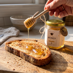 Honey being drizzled onto toast with a jar of honey in the background.